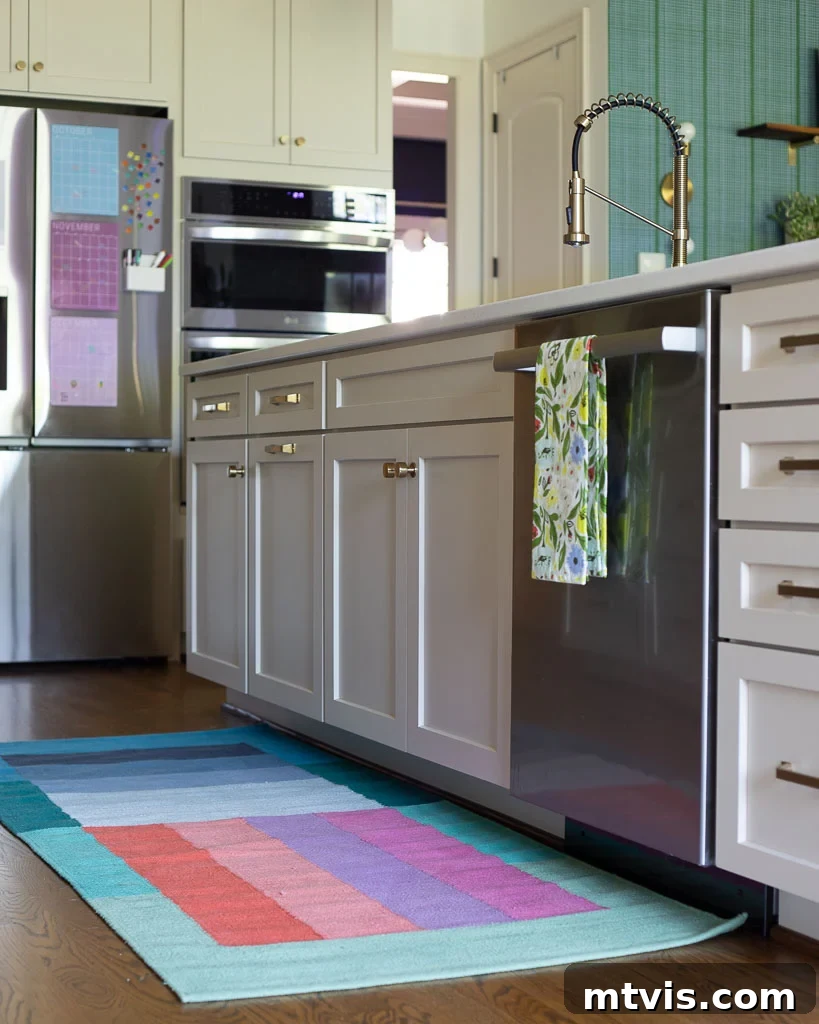 Our Kitchen Reveal: Serene Neutrals, Lively Hues 15 Kitchen detail showcasing a colorful kitchen runner, a delicate bud vase, and a framed orange blossom print, adding subtle pops of color to the neutral space and enhancing its vibrancy.