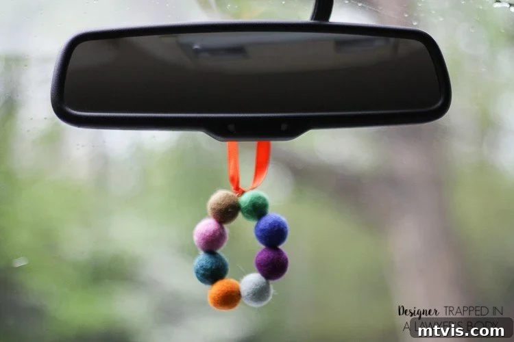 Homemade Pure Car Fragrance 11 A DIY car air freshener made of colorful felt balls hang from a rearview mirror.