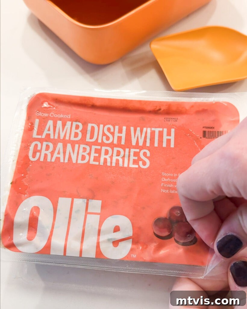 Our Dogs' Transformation on Ollie's Fresh Food 7 A woman's hands carefully opening a package of fresh Ollie dog food