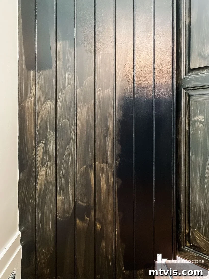 My Triple-Tested Method for Perfectly Painted Kitchen Cabinets 13 image of beadboard kitchen cabinetry partially painted with black paint from Fusion Mineral Paint--one side shows coverage from single coat, the other side shows corage with a second coat of paint, illustrating paint coverage