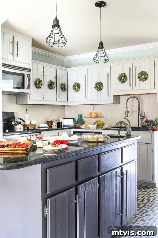 My Triple-Tested Method for Perfectly Painted Kitchen Cabinets 10 photo of kitchen with light and dark gray kitchen cabinets decorated for Christmas with mini wreaths hanging on the cabinet doors, illustrating durability over time
