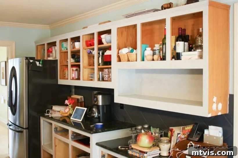 Will DIY Painted Kitchen Cabinets Stand the Test of Time? 3 Close-up photo of oak kitchen cabinets being painted a light gray color, showing the transformation in progress
