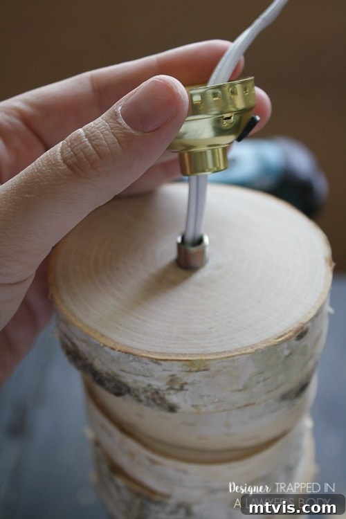 DIY Stacked Wood Lamp: Designer Style on a Budget 12 Attaching the collar component of the lamp socket to the threaded pipe