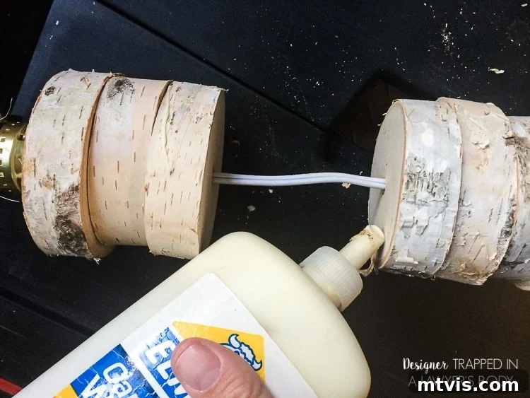 DIY Stacked Wood Lamp: Designer Style on a Budget 16 Applying wood glue between stacked wood slices to secure them