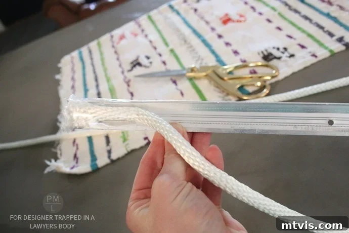Craft Your Own Hammock Chair 14 Hand holding a makeshift rope guide (taped closet piece) used to thread rope through fabric channels.