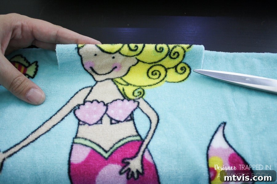 Upcycle Your Beach Towel into a Trendy Cover-Up 4 Cutting the head opening on a folded beach towel for a DIY cover-up.