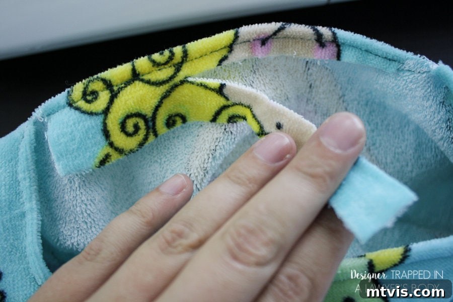 Sewing the hem around the head opening of a DIY beach towel cover-up.