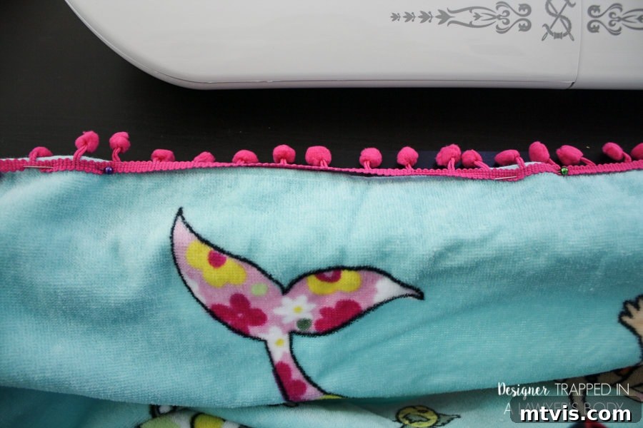Upcycle Your Beach Towel into a Trendy Cover-Up 8 Pinning vibrant pom-pom trim to the bottom hem of a DIY beach towel cover-up.