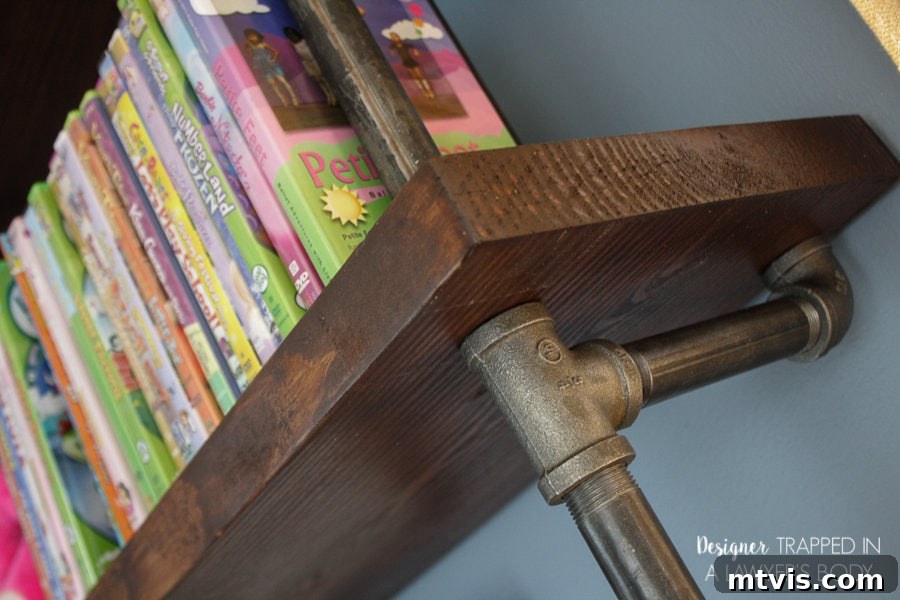 Industrial Chic: DIY Pipe Shelves and Integrated Workspaces 15 The built-in desk area of the industrial pipe unit, featuring organized supplies and a functional workspace for children.