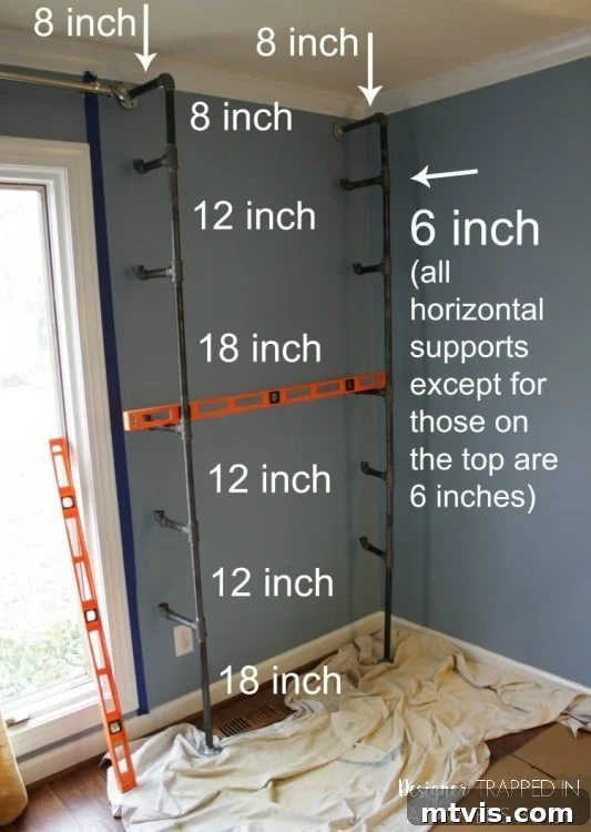 Industrial Chic: DIY Pipe Shelves and Integrated Workspaces 5 A partially assembled industrial pipe shelving unit skeleton, showing the T-joints and vertical pipes being test-fitted in the space.