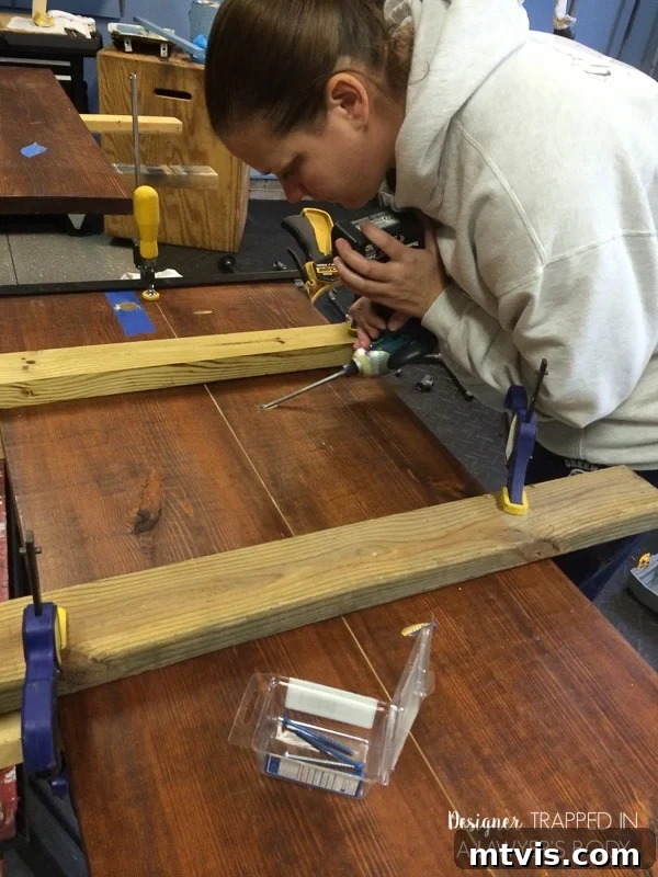 Industrial Chic: DIY Pipe Shelves and Integrated Workspaces 6 Close-up of pine boards being joined with a Kreg jig for the built-in desk, showcasing the strong, hidden pocket hole joinery.