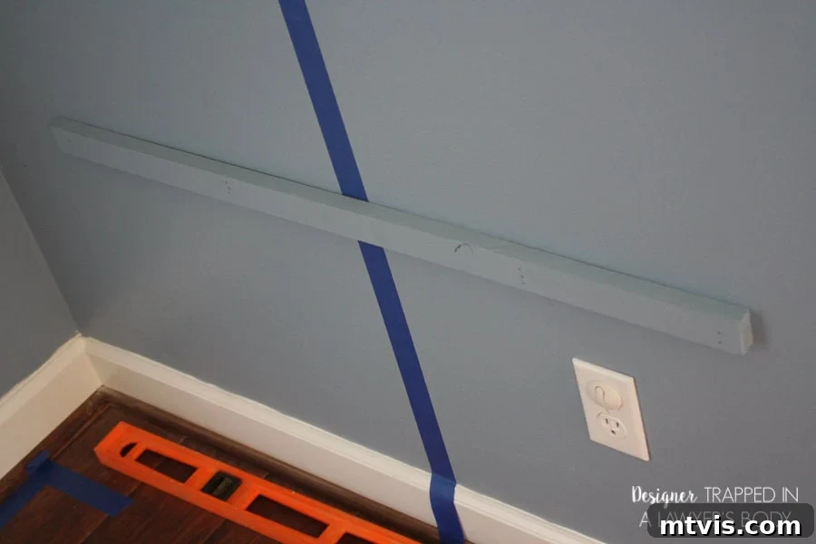 Industrial Chic: DIY Pipe Shelves and Integrated Workspaces 7 Installation of a wall bracket for desk support, showing how it will align with the rear of the built-in desk for stability.