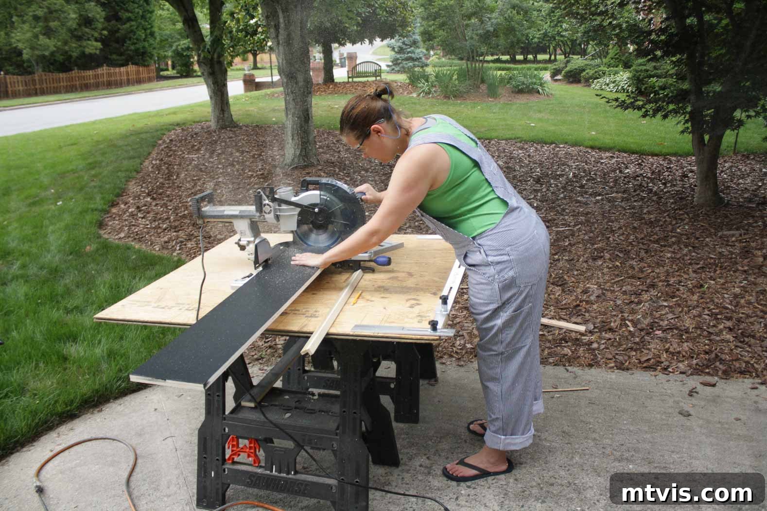 Man accurately cutting a new stair riser to size using a saw, essential for a perfect fit in DIY hardwood stairs