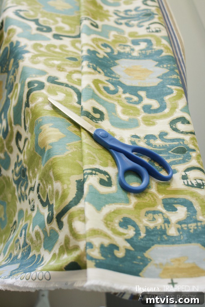 Preparing your fabric by folding and cutting for perfectly sized DIY curtain panels.