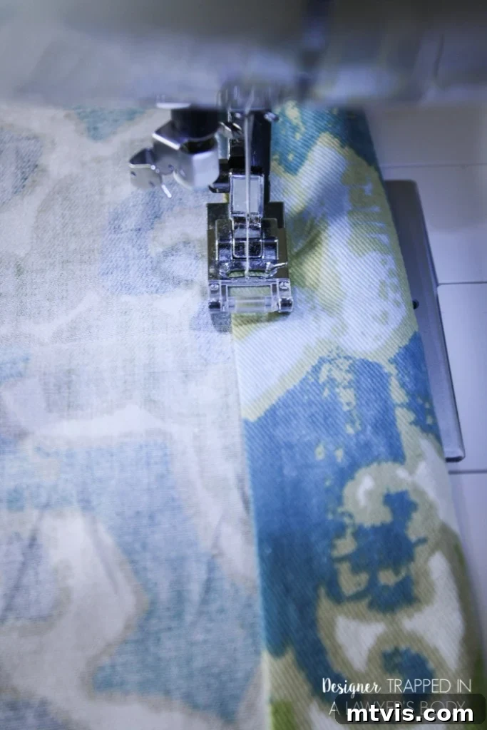 Sewing the ironed hems with a straight stitch for durable and beautiful DIY curtains.