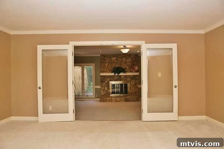 Stylish Concrete Fireplace Build for Under 100 13 An outdated living room with an old stone veneer fireplace before the DIY concrete makeover, showing its cluttered and traditional appearance.