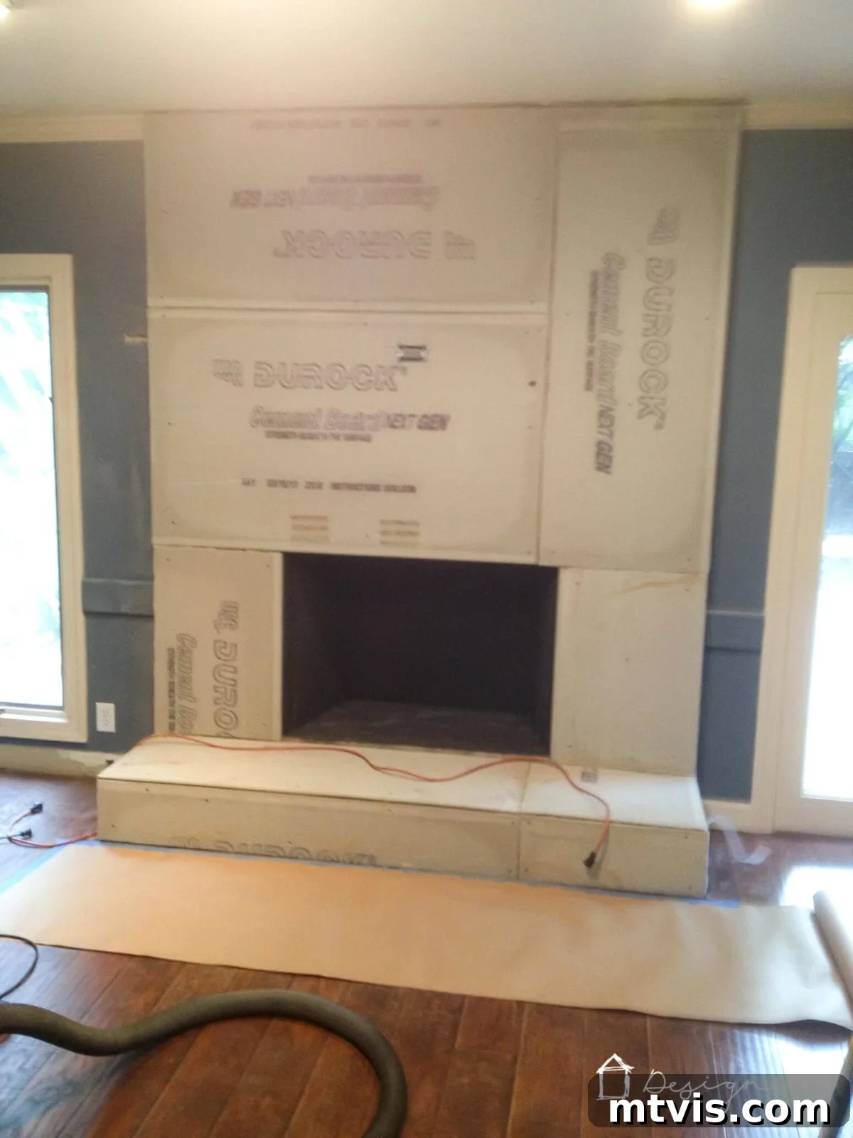Stylish Concrete Fireplace Build for Under 100 6 Cement board meticulously attached to a brick fireplace with mesh tape covering the seams, creating a smooth and stable base for the concrete overlay.