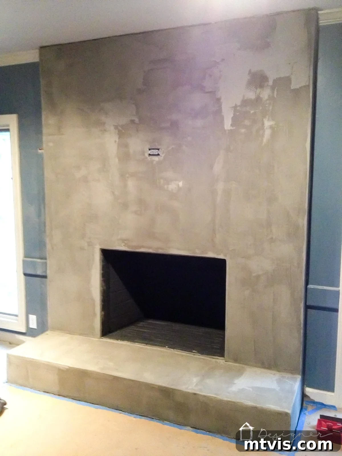 Stylish Concrete Fireplace Build for Under 100 9 The concrete fireplace after multiple coats, showcasing how the seams have completely disappeared and a smooth, uniform finish has been achieved.