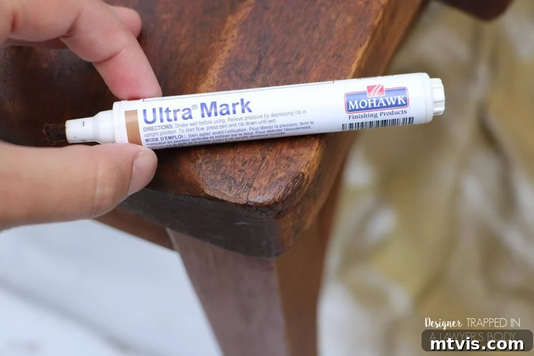 Effortless Wood Chair Refinishing 9 Applying a Mohawk touch-up marker to blend minor imperfections on the wood chair's surface for an enhanced finish.