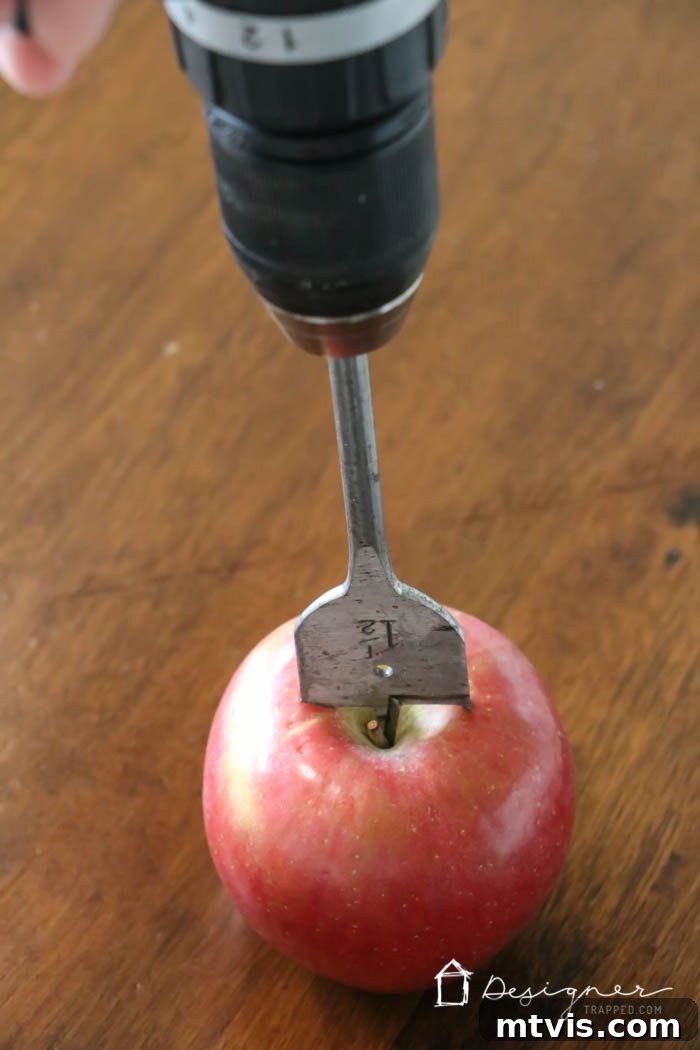 Crafting Homemade Apple Candles 3 Using a paddle drill bit to create a tea light holder in a fresh apple for a DIY centerpiece